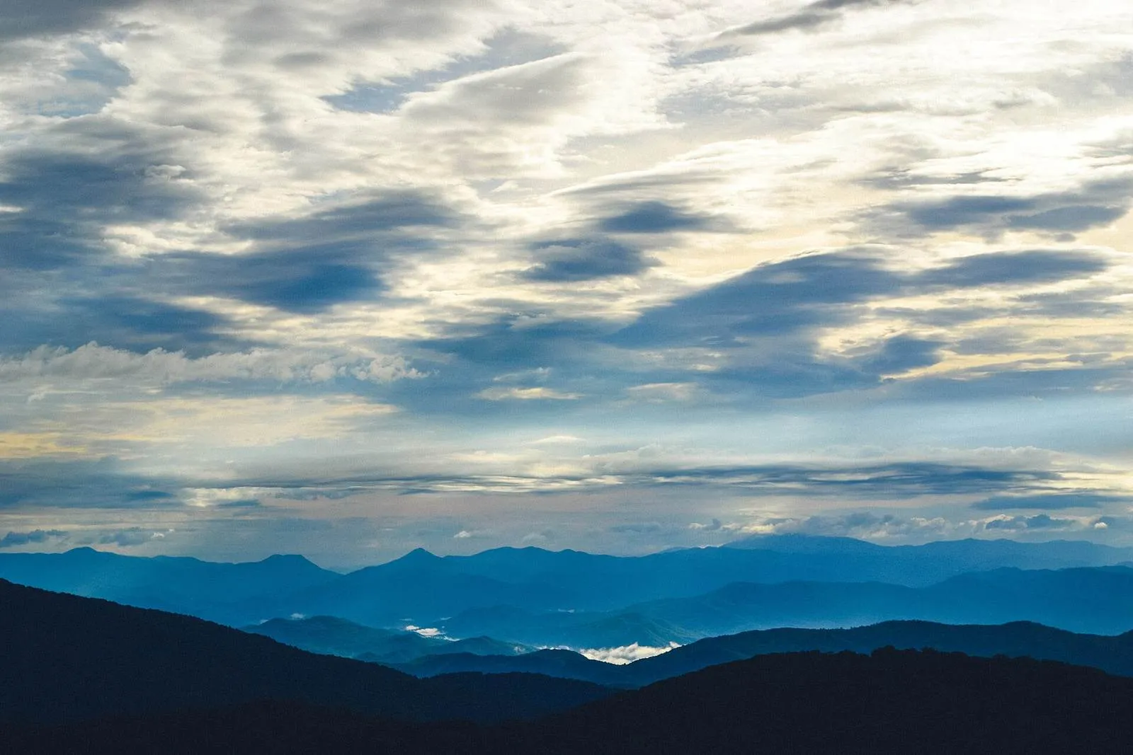 Layered blue ridgelines folding away at dawn